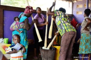 Des vendeurs en train de piler du Fufu